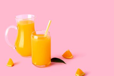 Pembe arka planda bir bardak taze portakal suyu.