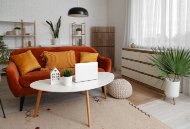 Ahşap perdeli, kırmızı kanepeli ve masalı bir oturma odası.