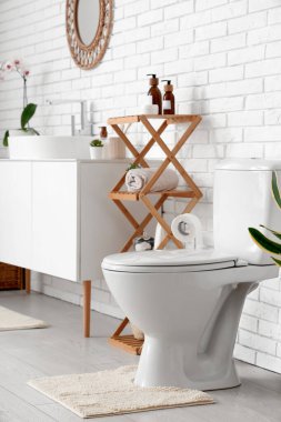 Tuvaletin içinde klozet ve raf ünitesi var.