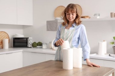 Mutfakta kağıt havluları olan genç bir kadın.