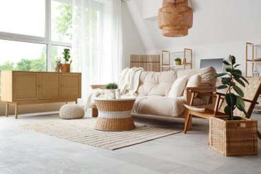 Oturma odasının iç tarafında sandık, çekmece ve kanepe olan hasır masa.