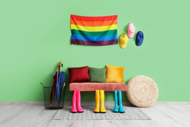 Salonun içinde bank, çizme ve LGBT bayrağı var.