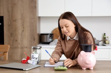 Eğitim için biriktirdiği bütçeyi evde planlayan genç bir kadın.