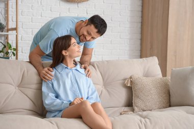 Evdeki kanepede pijamalı mutlu bir çift.