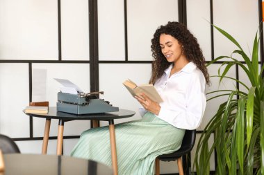 Kafedeki masada daktilo okuyan genç bir Afro-Amerikalı yazar.