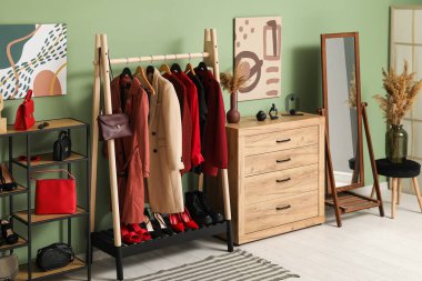 Kadın giysileri, ayakkabıları ve otları olan modern giyinme odasının şık bir iç mekanı.