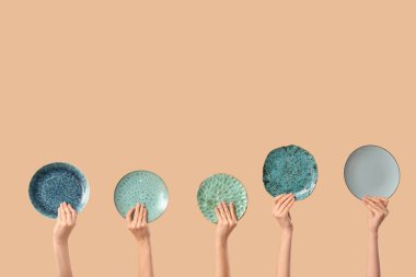 Bej arka planda farklı plakalı kadın elleri