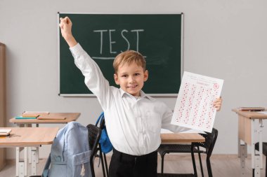 Sınıfta test sonuçları alan tatlı bir okul çocuğu.