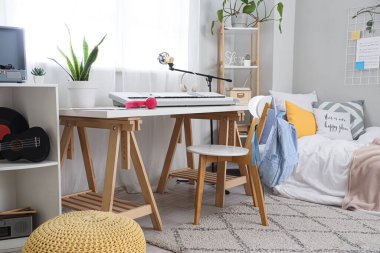 Yatak odasının içinde, masada ve rafta sentezleyici var.