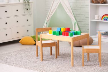 Çocuk odasındaki masada plastik küpler.