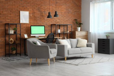 Rahat kanepesi, rahat iş yeri ve modern bilgisayarı olan bir oda.