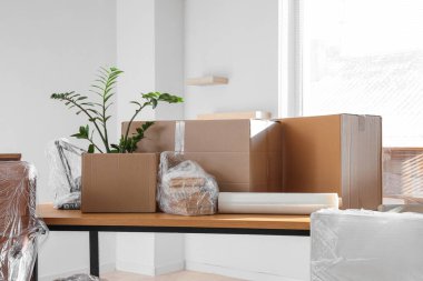 Taşındığı gün ofisinde esneme ambalajı ve karton kutular olan masa