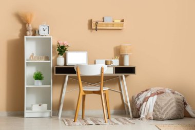 Modern dizüstü bilgisayarı ve güzel çiçekleri olan şık bir çalışma alanı.