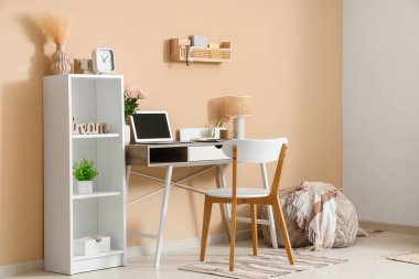 Modern dizüstü bilgisayarı ve güzel çiçekleri olan şık bir çalışma alanı.