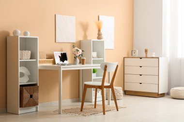 Modern dizüstü bilgisayarı ve güzel çiçekleri olan şık bir çalışma alanı.