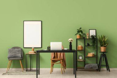 Modern dizüstü bilgisayarı ve güzel çiçekleri olan şık bir çalışma alanı.