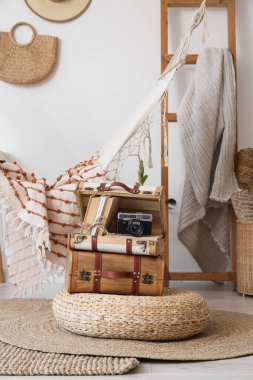 Fotoğraf makineli bavullar ve odada puf üzerine kitaplar.