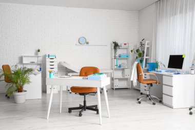 Masaları ve raf üniteleri olan bir tıp bürosu.