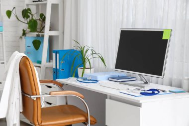 Tıp bürosunda boş bilgisayar monitörü olan bir doktorun işyeri.