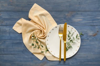 Mavi ahşap arka planda okaliptüs dalları olan güzel bir masa.