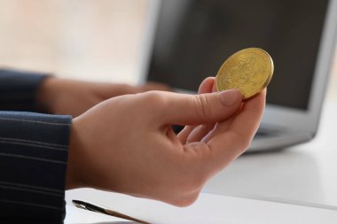 Ofisteki masada bilgisayarını kullanan Bitcoin 'li genç bir iş kadını.