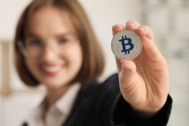 Ofisinde Bitcoin olan genç iş kadını, yakın plan.