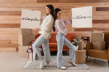 Evde şık posterleri olan genç kadınlar.