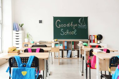 GOODBYE OKULU yazılı karatahta ve sınıf içi aydınlık duvara çizilmiş tekne