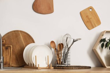 Tabaklı ahşap tezgah ve farklı mutfak aletleri, yakın plan.