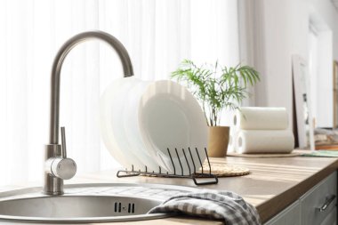 Mutfak penceresinin yanındaki tezgahta tabakla lavabo.