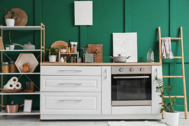 Mutfağın içinde raf ünitesi, merdiven ve çatal bıçak var.