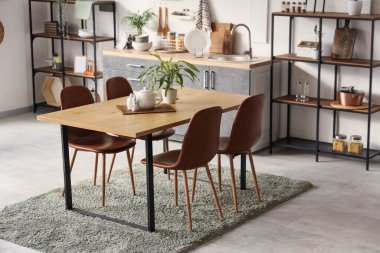 Mutfağın içinde yemek masası ve bitkiler var.