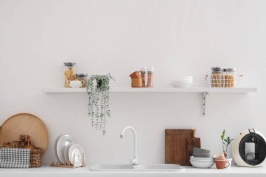 Mutfaktaki ışıklı duvarda mutfak gereçleri olan tezgah ve raf.