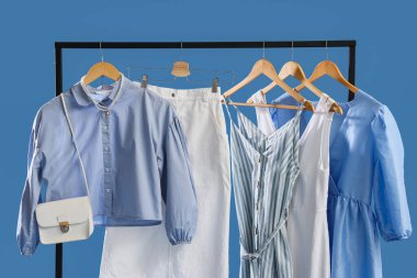 Şık kıyafetler ve mavi arka planda çanta.