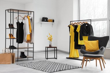 Elbise askıları ve koltuğu olan bir stilistin stüdyosu.