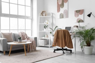 Çalışma yeri, kanepesi ve bitkileri olan bir ofis.