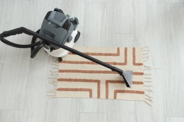 Modern elektrikli süpürge, şık halı, üst manzara.