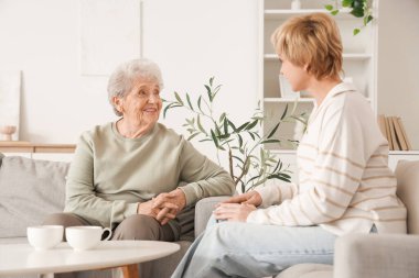 Kızıyla birlikte evdeki kanepede oturan son sınıf öğrencisi bir kadın. Anneler Günü kutlaması