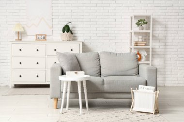 Oturma odasının içinde kanepe, dergi standı ve masada takvim var.