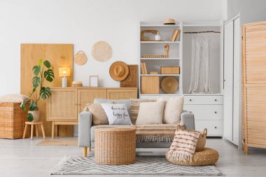 Kitaplık, kanepe ve sepetlerle aydınlık oturma odasının içinde.