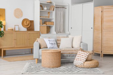 Kitaplık, kanepe ve sepetlerle aydınlık oturma odasının içinde.