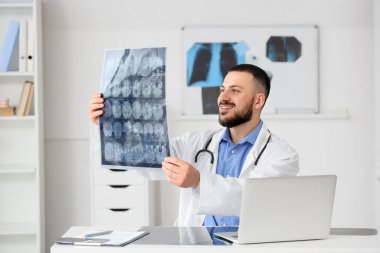Erkek doktor klinikteki masada kafa MRI taraması yapıyor.