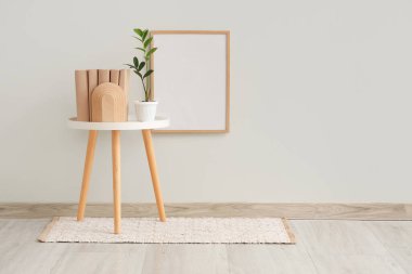 Çiçekli masa ve odanın içindeki beyaz duvarın yanında kitaplar.