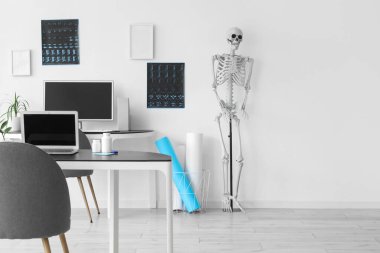 İnsan iskeleti modeli, röntgen görüntüleri, modern dizüstü bilgisayar ve ışık hastanesi.