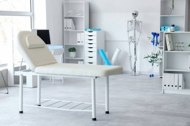 İnsan iskeleti modeli ve kanepesi olan hafif bir hastane.