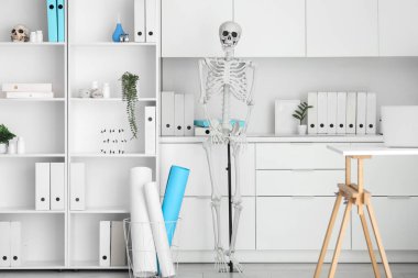 Masada insan iskeleti modeli ve modern dizüstü bilgisayarı olan hafif bir hastane.