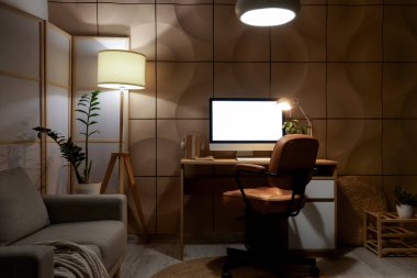 Çalışma odası, katlanan ekran ve parlayan lambalar olan karanlık ofisin içinde.