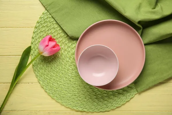 Sarı ahşap arka planda pembe lale çiçekli güzel bir masa.