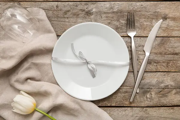 Ahşap zemin üzerinde beyaz lale çiçeği olan güzel bir masa.