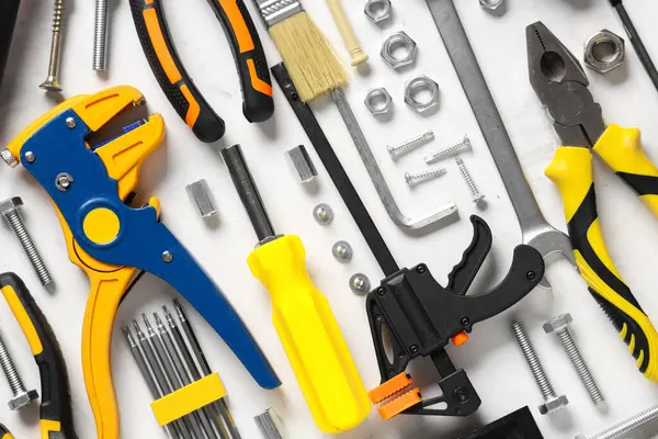 Beyaz grunge arkaplan üzerinde inşaat araçları düzenleme, yakın çekim